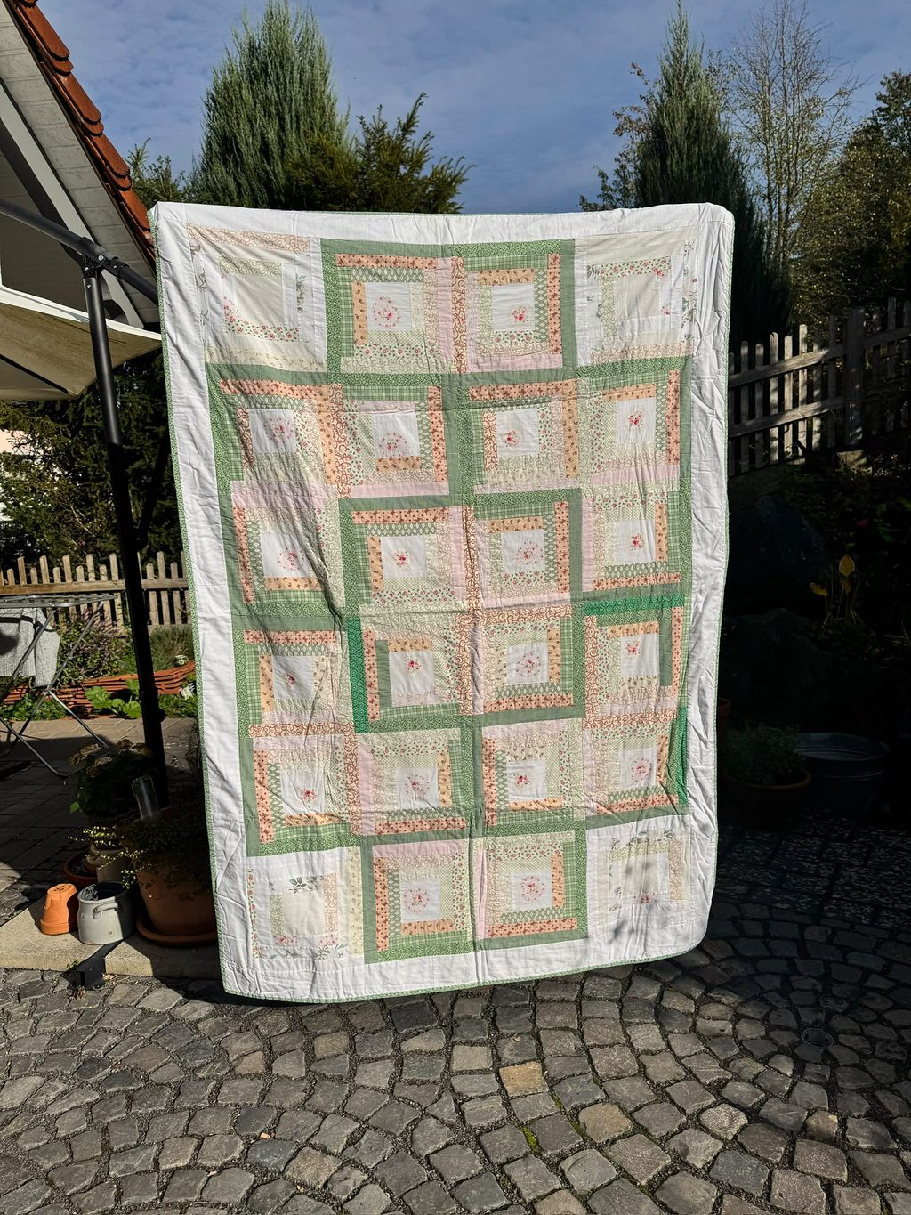Log Cabin No. 1: a quilt of log cabin blocks in green, pink and white.