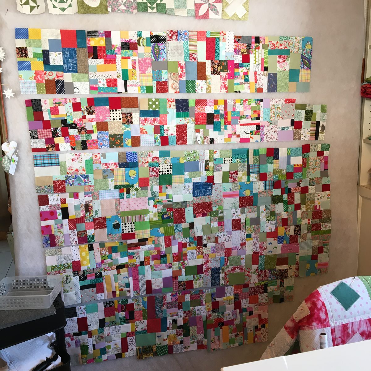Scrap Vortex: Hunderte kleine Stoffstücke, Reihe für Reihe an der Designwand zusammengesetzt.