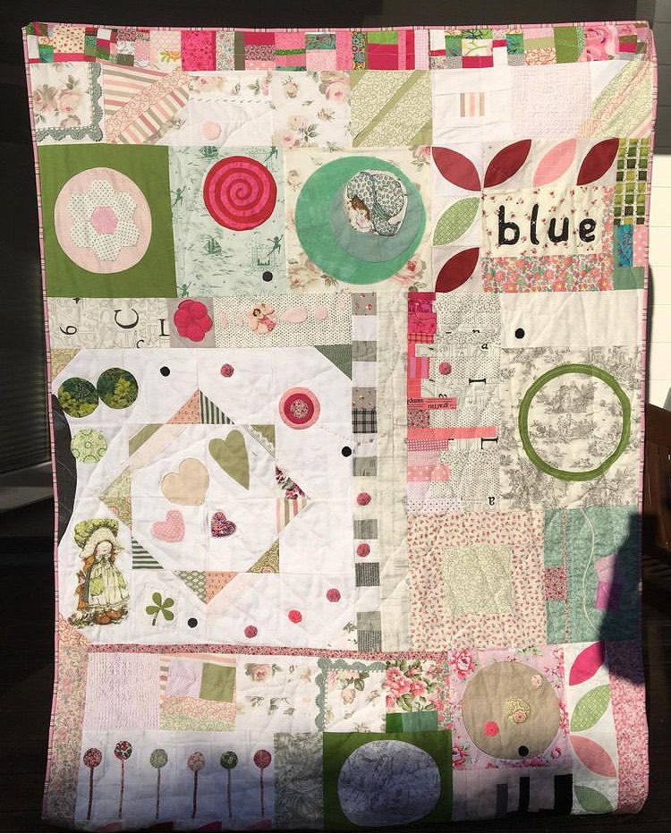 The Vignettes Quilt with improvised blocks in white, green and pink, quilted by hand.